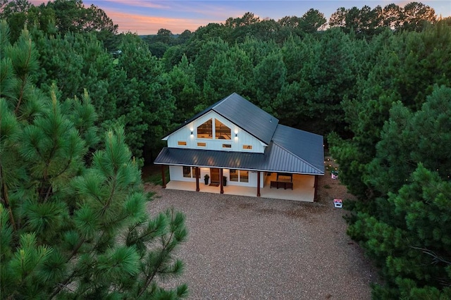 2690 Sweet Home Rd, Broken Bow, OK 74728 - view of front of house with gravel driveway, a view of trees, and metal roof