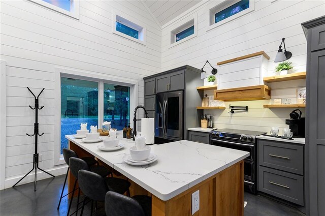 2690 Sweet Home Rd, Broken Bow, OK 74728 - kitchen featuring appliances with stainless steel finishes, concrete flooring, gray cabinetry, open shelves, and light stone countertops