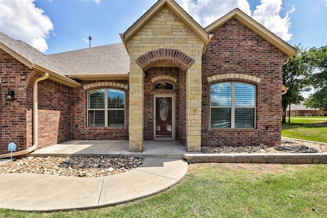 3327 Bobcat Trl, Guthrie, OK 73044 - doorway to property with brick siding, a shingled roof, and a lawn