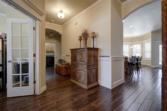 3327 Bobcat Trl, Guthrie, OK 73044 - hallway with arched walkways, dark wood-type flooring, crown molding, and a wainscoted wall