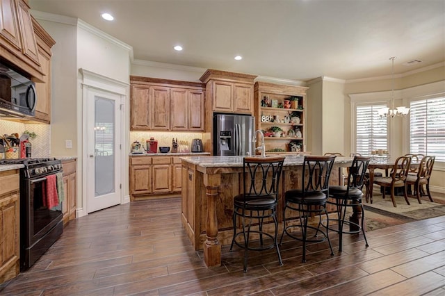 3327 Bobcat Trl, Guthrie, OK 73044 - kitchen with range with gas stovetop, stainless steel fridge, dark wood-style flooring, a breakfast bar area, and an island with sink