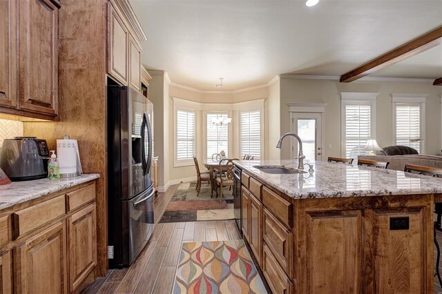 3327 Bobcat Trl, Guthrie, OK 73044 - kitchen featuring refrigerator with ice dispenser, brown cabinetry, black dishwasher, light stone counters, and dark wood-style flooring