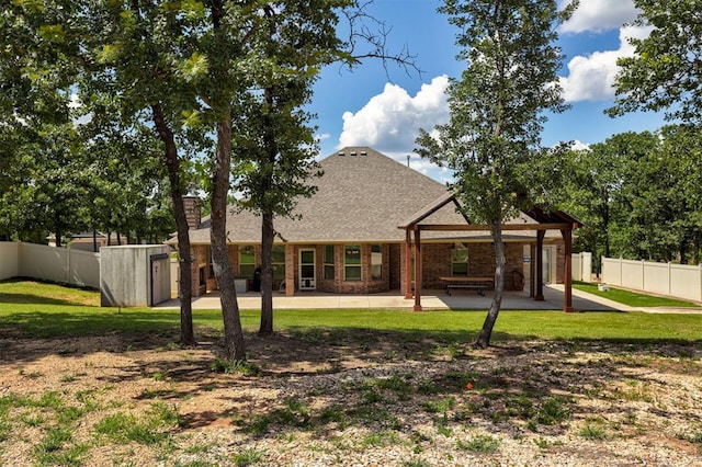 3327 Bobcat Trl, Guthrie, OK 73044 - rear view of property featuring a patio, a shingled roof, a storage unit, and brick siding