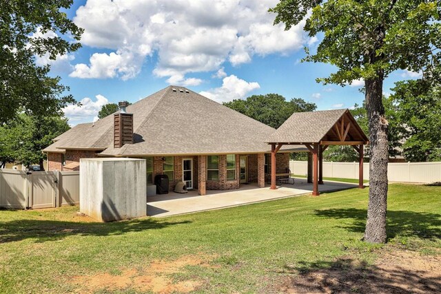 3327 Bobcat Trl, Guthrie, OK 73044 - back of property with a chimney, brick siding, a shingled roof, and a patio