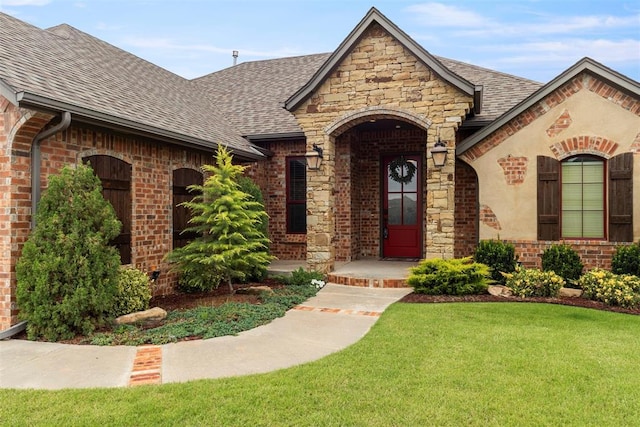 10921 SW 20th St, Yukon, OK 73099 - view of front of house featuring a shingled roof, a front lawn, brick siding, and stone siding