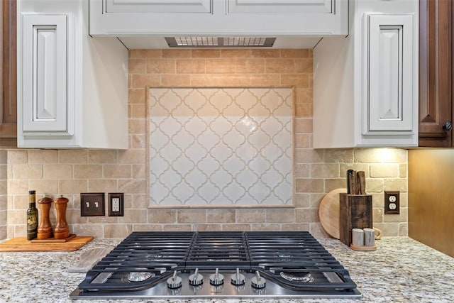 10921 SW 20th St, Yukon, OK 73099 - kitchen featuring stainless steel gas stovetop, white cabinets, and decorative backsplash