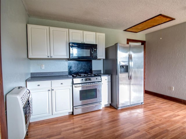 344020 E 760th Rd, Agra, OK 74824 - kitchen featuring appliances with stainless steel finishes, dark countertops, white cabinetry, a textured ceiling, and a textured wall