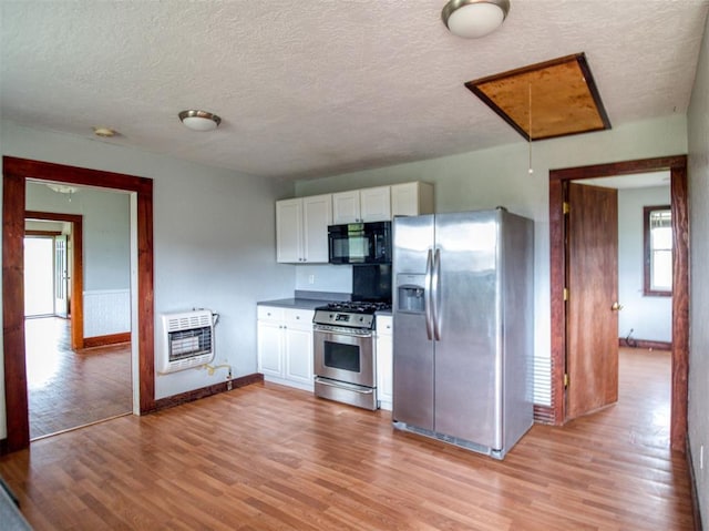 344020 E 760th Rd, Agra, OK 74824 - kitchen with stainless steel appliances, heating unit, white cabinetry, light wood-style flooring, and a textured ceiling