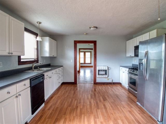 344020 E 760th Rd, Agra, OK 74824 - kitchen featuring black appliances, a sink, heating unit, healthy amount of natural light, and a textured ceiling