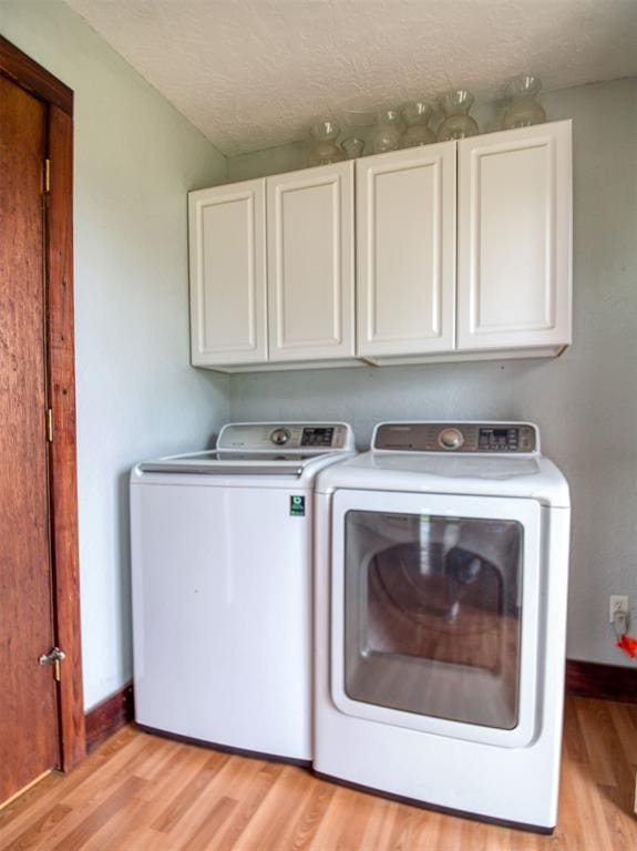 344020 E 760th Rd, Agra, OK 74824 - laundry area with cabinet space, separate washer and dryer, light wood-type flooring, baseboards, and a textured ceiling