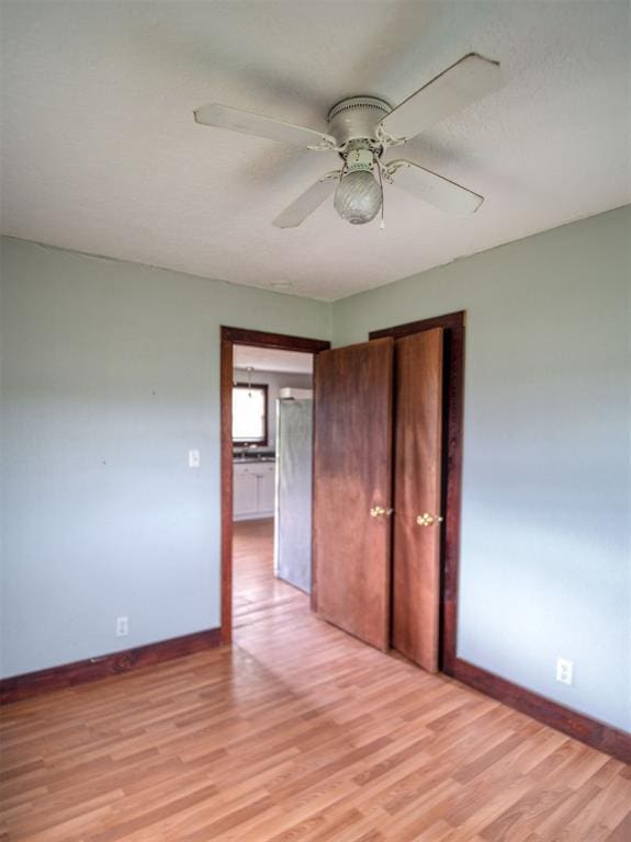 344020 E 760th Rd, Agra, OK 74824 - unfurnished bedroom featuring refrigerator, light wood-style floors, baseboards, and ceiling fan