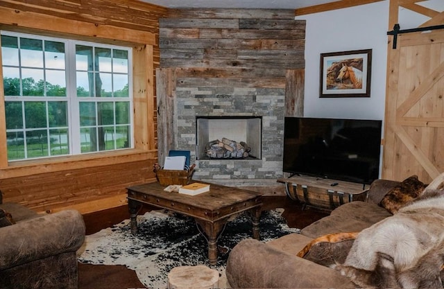 16301 Lewis Rd, Lexington, OK 73051 - living area featuring wood walls, a stone fireplace, a barn door, and crown molding