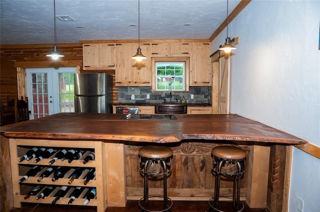 16301 Lewis Rd, Lexington, OK 73051 - kitchen with freestanding refrigerator, wooden counters, decorative backsplash, a sink, and a breakfast bar