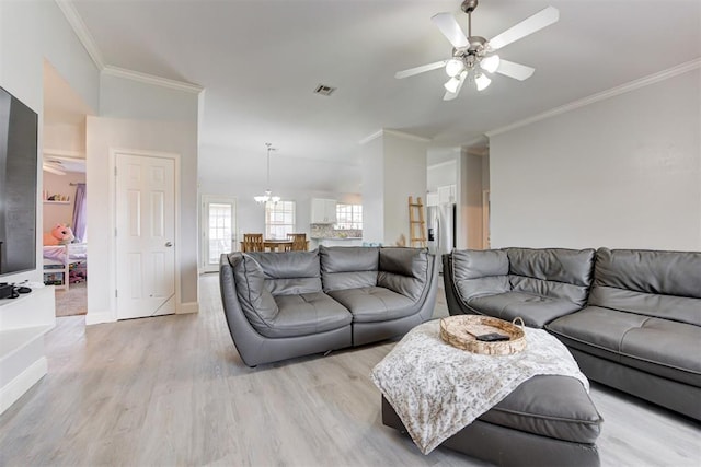 2333 Berry Ln, Midwest City, OK 73130 - living room with light wood finished floors, ornamental molding, ceiling fan, a chandelier, and baseboards