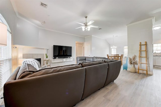 2333 Berry Ln, Midwest City, OK 73130 - living room with light wood-style floors, ceiling fan, a tile fireplace, crown molding, and lofted ceiling