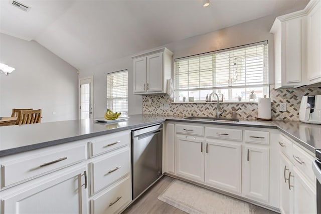 2333 Berry Ln, Midwest City, OK 73130 - kitchen featuring dishwasher, a sink, tasteful backsplash, lofted ceiling, and a peninsula
