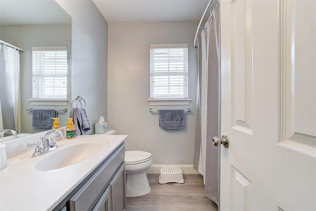 2333 Berry Ln, Midwest City, OK 73130 - full bathroom featuring vanity, wood finished floors, toilet, and baseboards