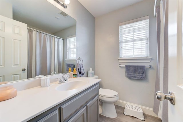 2333 Berry Ln, Midwest City, OK 73130 - bathroom featuring vanity, toilet, baseboards, and wood finished floors