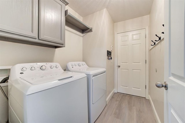 2333 Berry Ln, Midwest City, OK 73130 - washroom with light wood-style flooring, washer and clothes dryer, cabinet space, and baseboards