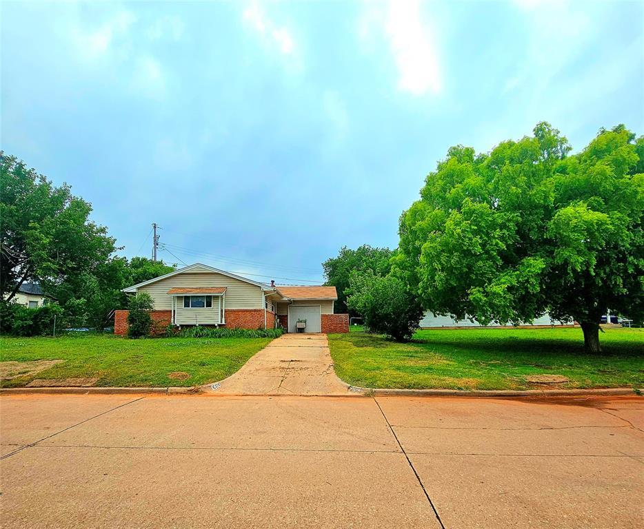 6116 SE 3rd St, Midwest City, OK 73110 - view of front of home featuring concrete driveway, a front lawn, brick siding, and an attached garage