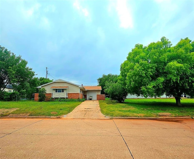 6116 SE 3rd St, Midwest City, OK 73110 - view of front of home featuring concrete driveway, a front lawn, brick siding, and an attached garage