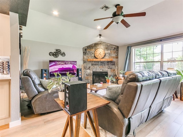 4409 Newport Dr, Norman, OK 73072 - living area with a ceiling fan, light wood-style floors, lofted ceiling, and a stone fireplace