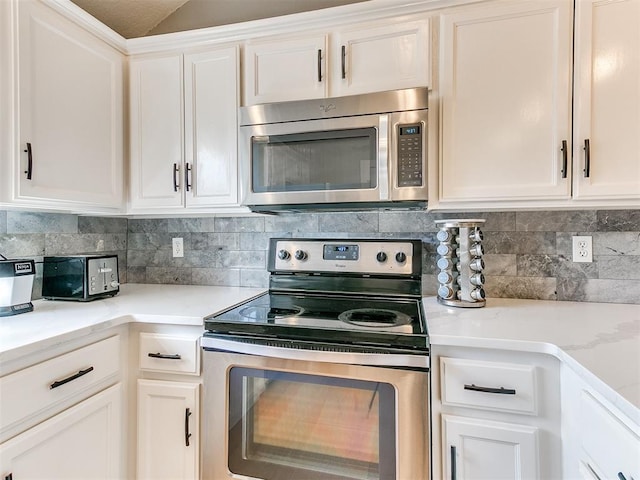4409 Newport Dr, Norman, OK 73072 - kitchen with appliances with stainless steel finishes, tasteful backsplash, white cabinetry, and light stone counters