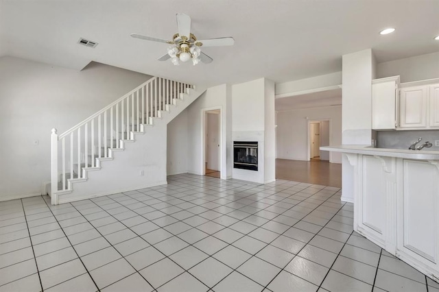 15134 Scottsdale Ln, Choctaw, OK 73020 - unfurnished living room featuring a ceiling fan, stairs, baseboards, a glass covered fireplace, and recessed lighting