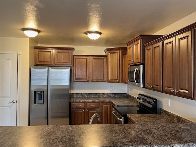 1400 Hillside Ter, Blanchard, OK 73010 - kitchen featuring stainless steel appliances, dark countertops, a sink, and brown cabinetry
