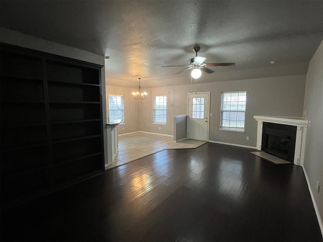414 SE 7th St, Lexington, OK 73051 - unfurnished living room with a chandelier, a fireplace with flush hearth, baseboards, ceiling fan, and wood finished floors