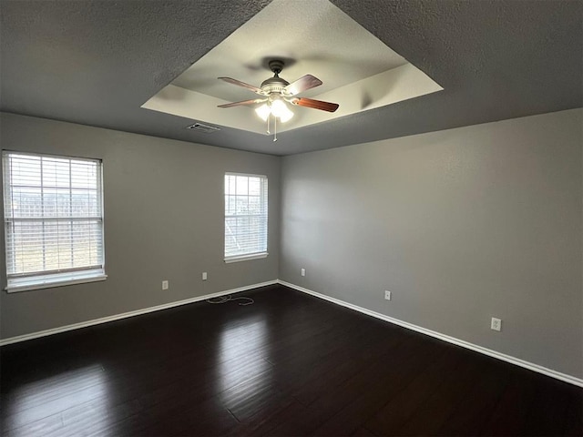 414 SE 7th St, Lexington, OK 73051 - empty room featuring a raised ceiling, a ceiling fan, dark wood-style flooring, baseboards, and a textured ceiling
