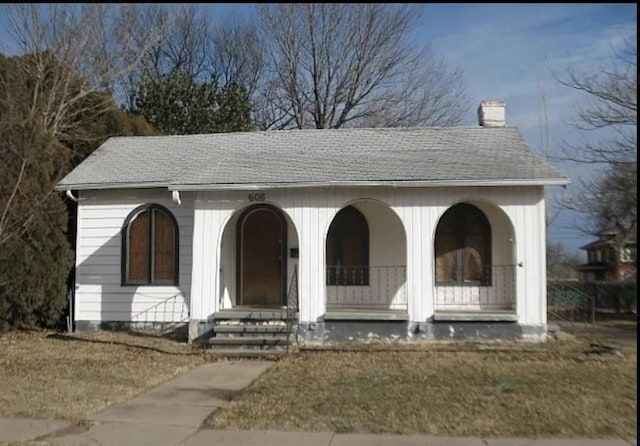606 N 7th St, Tonkawa, OK 74653 - view of front of property with a chimney, a shingled roof, and covered porch
