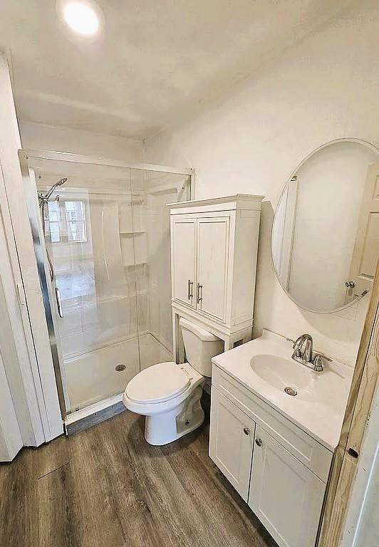 716 S 13th St, Frederick, OK 73541 - full bathroom with wood finished floors, vanity, a stall shower, and toilet
