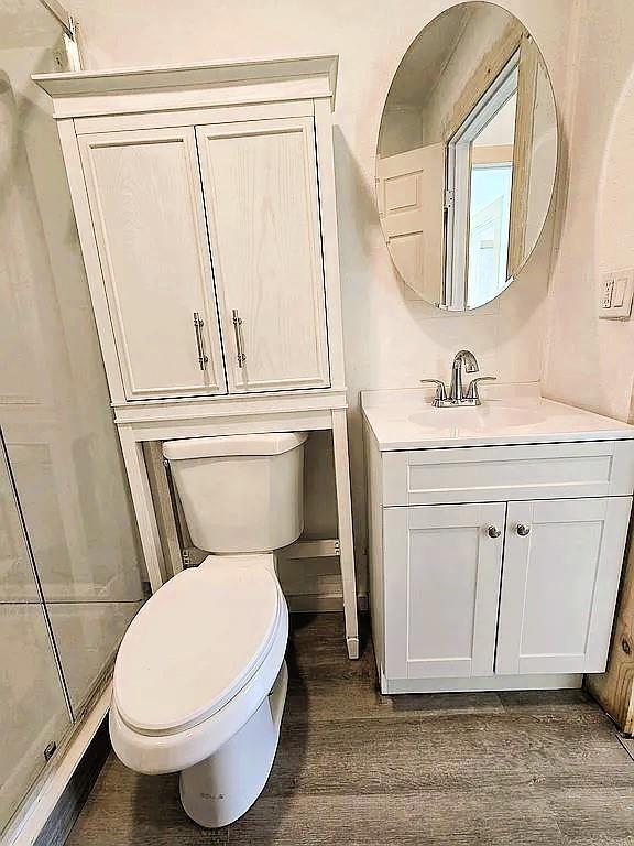716 S 13th St, Frederick, OK 73541 - bathroom featuring vanity, toilet, and wood finished floors