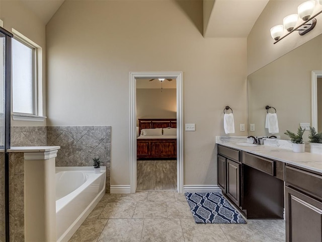 2500 Cordgrass Ln, Edmond, OK 73013 - bathroom featuring ensuite bath, a garden tub, double vanity, high vaulted ceiling, and baseboards
