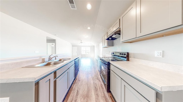 11817 NW 97th St, Yukon, OK 73099 - kitchen featuring electric stove, lofted ceiling, light wood-style flooring, a sink, and light countertops