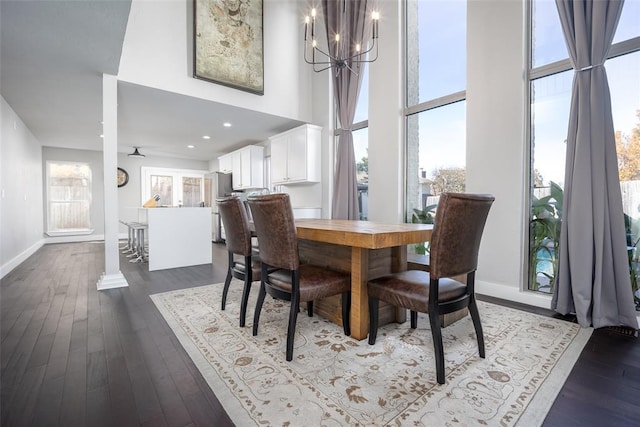 11000 Magnolia Park, Oklahoma City, OK 73120 - dining room featuring a towering ceiling, a chandelier, dark wood-type flooring, and baseboards