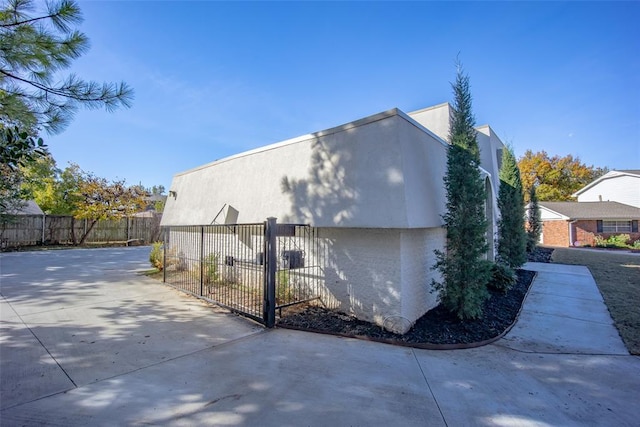 11000 Magnolia Park, Oklahoma City, OK 73120 - view of side of property featuring stucco siding and a gate