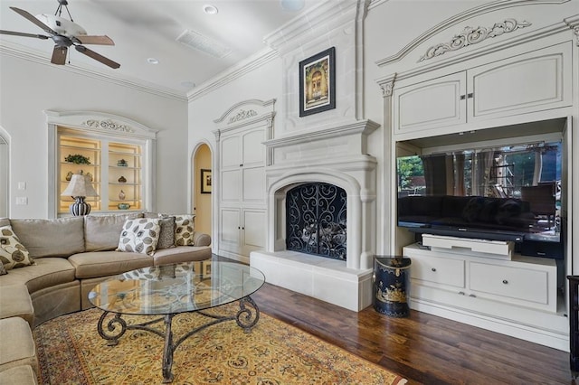 15005 Dourdan Ct, Oklahoma City, OK 73142 - living room featuring a ceiling fan, arched walkways, wood finished floors, crown molding, and a fireplace with raised hearth