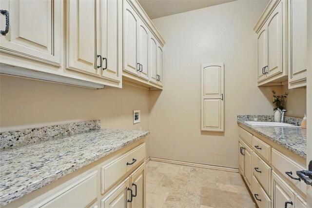 15005 Dourdan Ct, Oklahoma City, OK 73142 - washroom featuring cabinet space, washer hookup, stone finish flooring, and baseboards