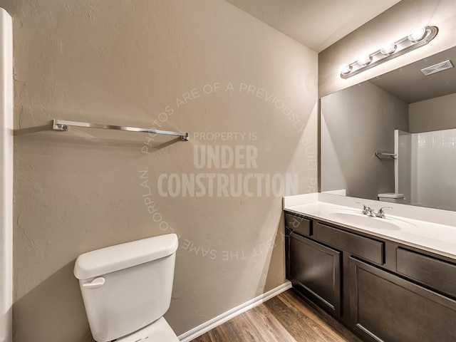 3909 S Ravine St, Stillwater, OK 74074 - bathroom with toilet, wood finished floors, vanity, and baseboards