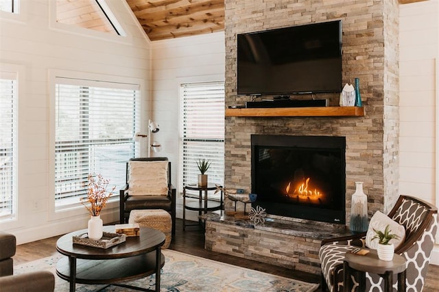 192 Grape Trl, Broken Bow, OK 74728 - living area featuring wood finished floors, wood ceiling, a stone fireplace, and wooden walls