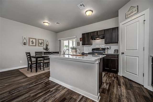 14201 Athens Ln, Yukon, OK 73099 - kitchen featuring dark wood finished floors, a sink, backsplash, and a center island with sink