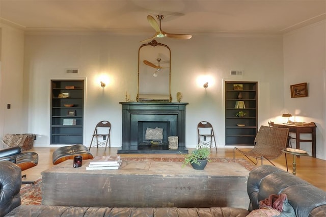 300 E Federal St, Shawnee, OK 74804 - living room featuring built in features, ornamental molding, ceiling fan, a fireplace with raised hearth, and wood finished floors