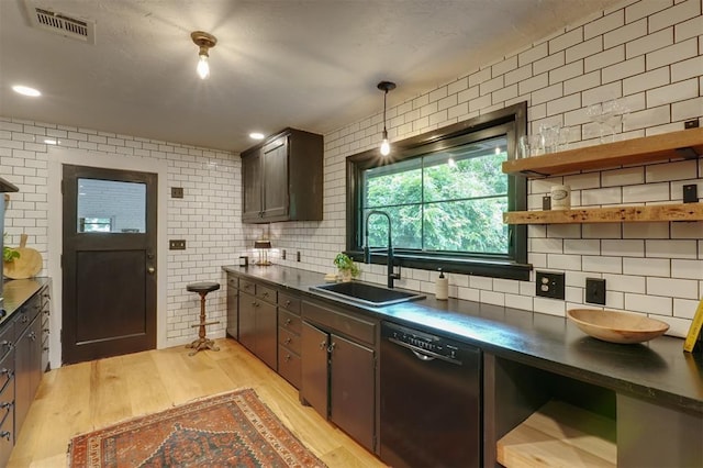 300 E Federal St, Shawnee, OK 74804 - kitchen featuring black dishwasher, dark countertops, a sink, tasteful backsplash, and tile walls