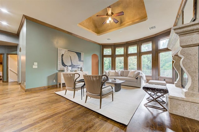 1918 Winding Ridge Rd, Edmond, OK 73034 - living room with a tray ceiling, arched walkways, ceiling fan, ornamental molding, and wood finished floors