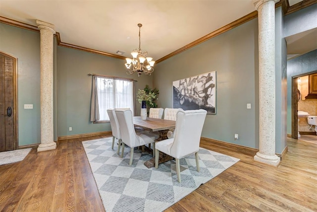 1918 Winding Ridge Rd, Edmond, OK 73034 - dining space featuring decorative columns, crown molding, wood finished floors, and a chandelier