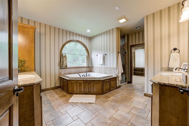 1918 Winding Ridge Rd, Edmond, OK 73034 - bathroom featuring wallpapered walls, a bath, stone finish flooring, and vanity