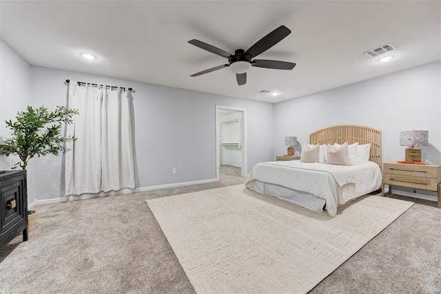 1918 Winding Ridge Rd, Edmond, OK 73034 - carpeted bedroom featuring a wood stove, a ceiling fan, recessed lighting, and a walk in closet