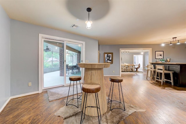 1918 Winding Ridge Rd, Edmond, OK 73034 - kitchen with wood finished floors, a kitchen breakfast bar, and track lighting